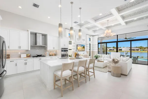 a large white kitchen with lots of counter space and windows