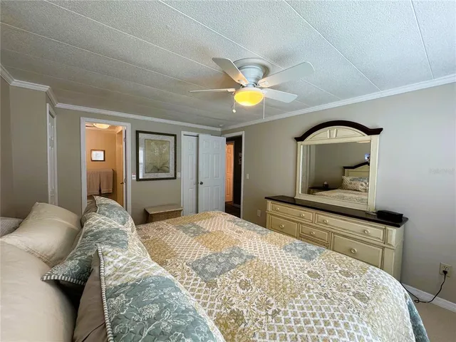 a bedroom with a bed and a dresser with mirror