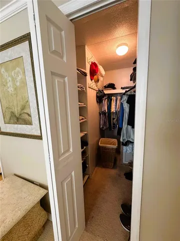 a hallway with painting on the wall and a large mirror