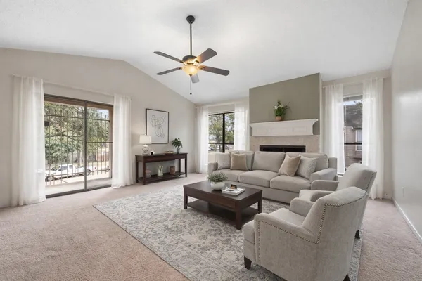 a living room with furniture ceiling fan and a window