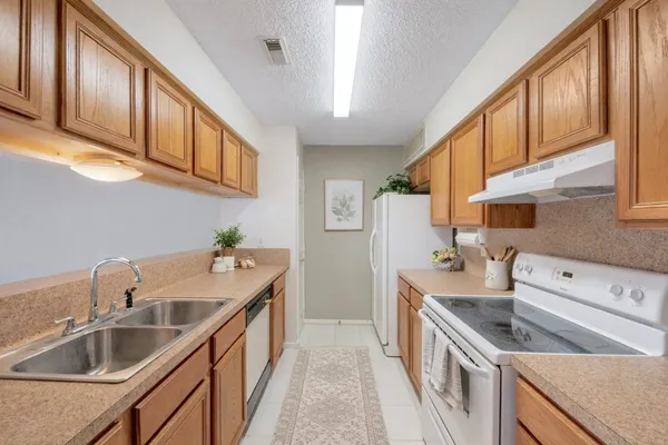 a kitchen with stainless steel appliances granite countertop a sink a stove and a refrigerator