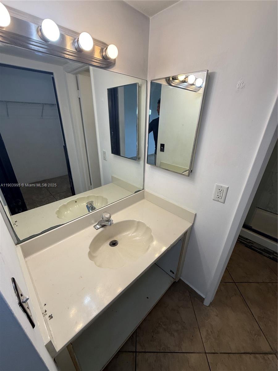 10253 Northwest 9th St Circle, Unit 4066 Miami, FL 33172 - Photo 21 of 27 a bathroom with a sink and a mirror