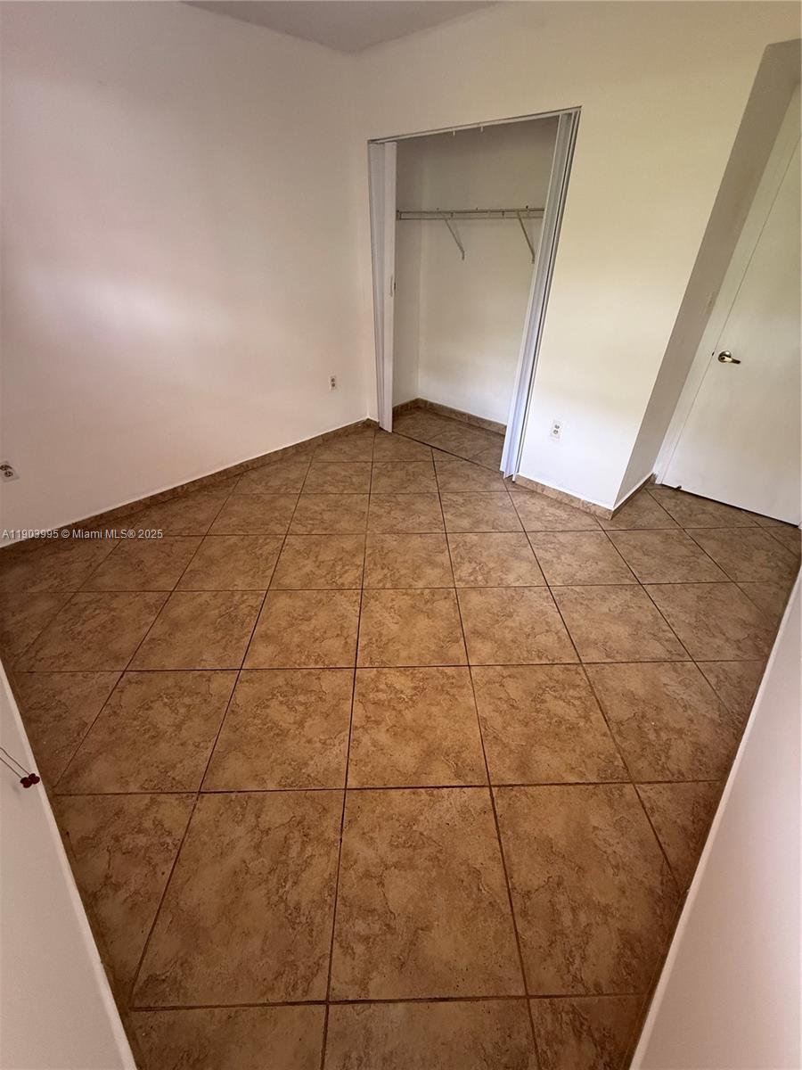 10253 Northwest 9th St Circle, Unit 4066 Miami, FL 33172 - Photo 24 of 27 a view of an empty room and with kitchen in the background
