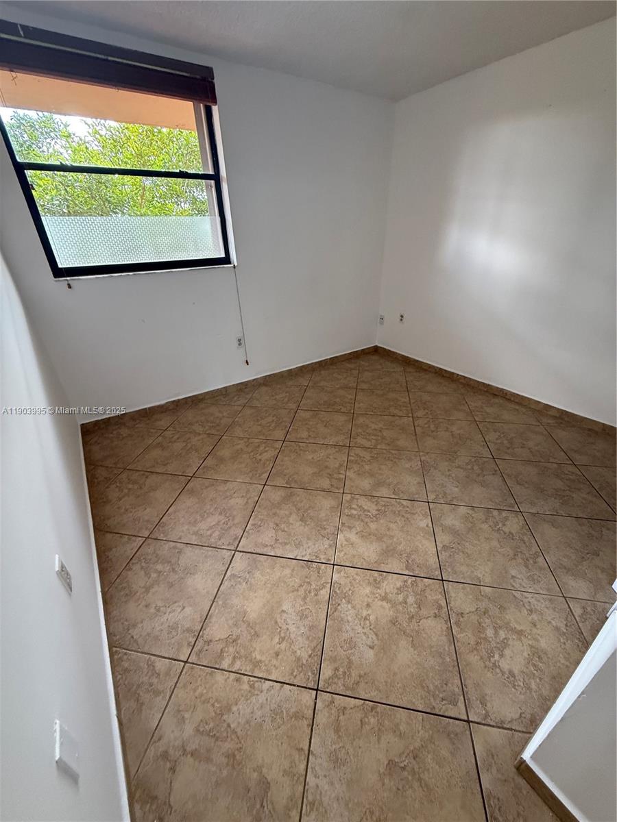10253 Northwest 9th St Circle, Unit 4066 Miami, FL 33172 - Photo 25 of 27 an empty room with windows