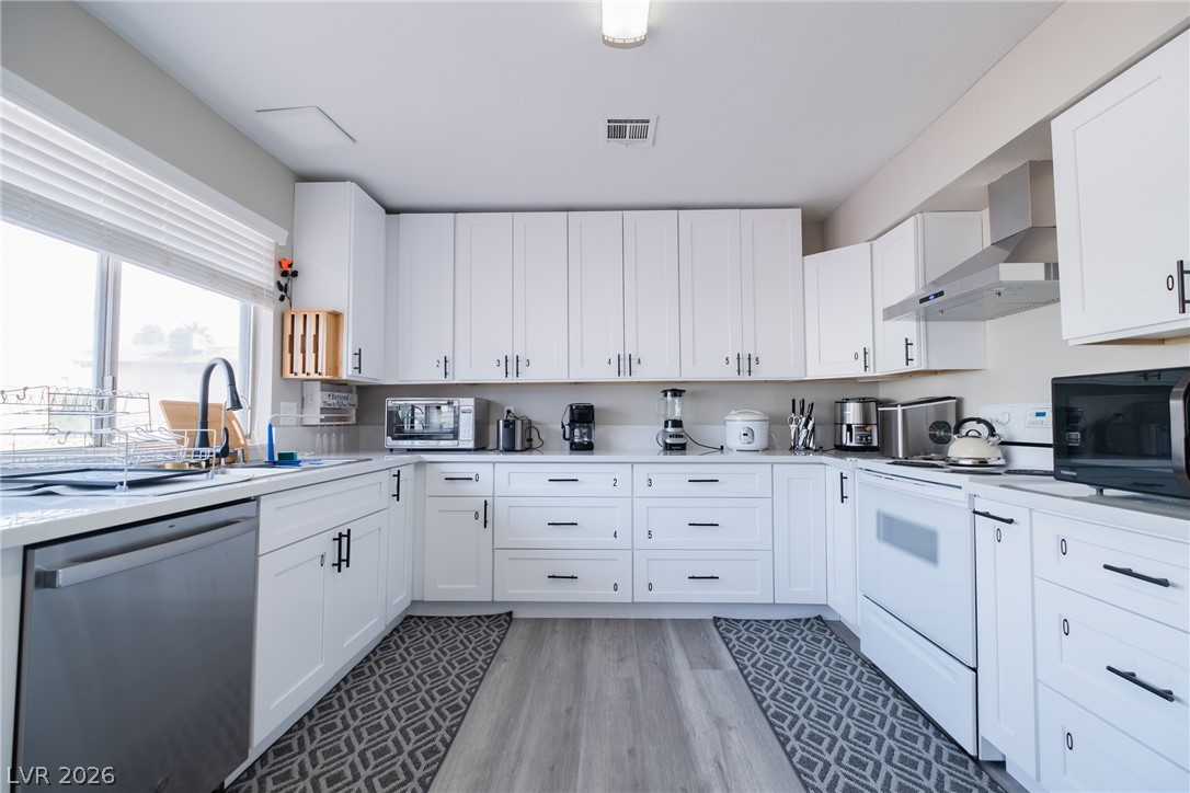 6356 West Viking Road Las Vegas, NV 89103 - Photo 13 of 51 Crisp white cabinetry paired with modern flooring defines this well-organized kitchen workspace.