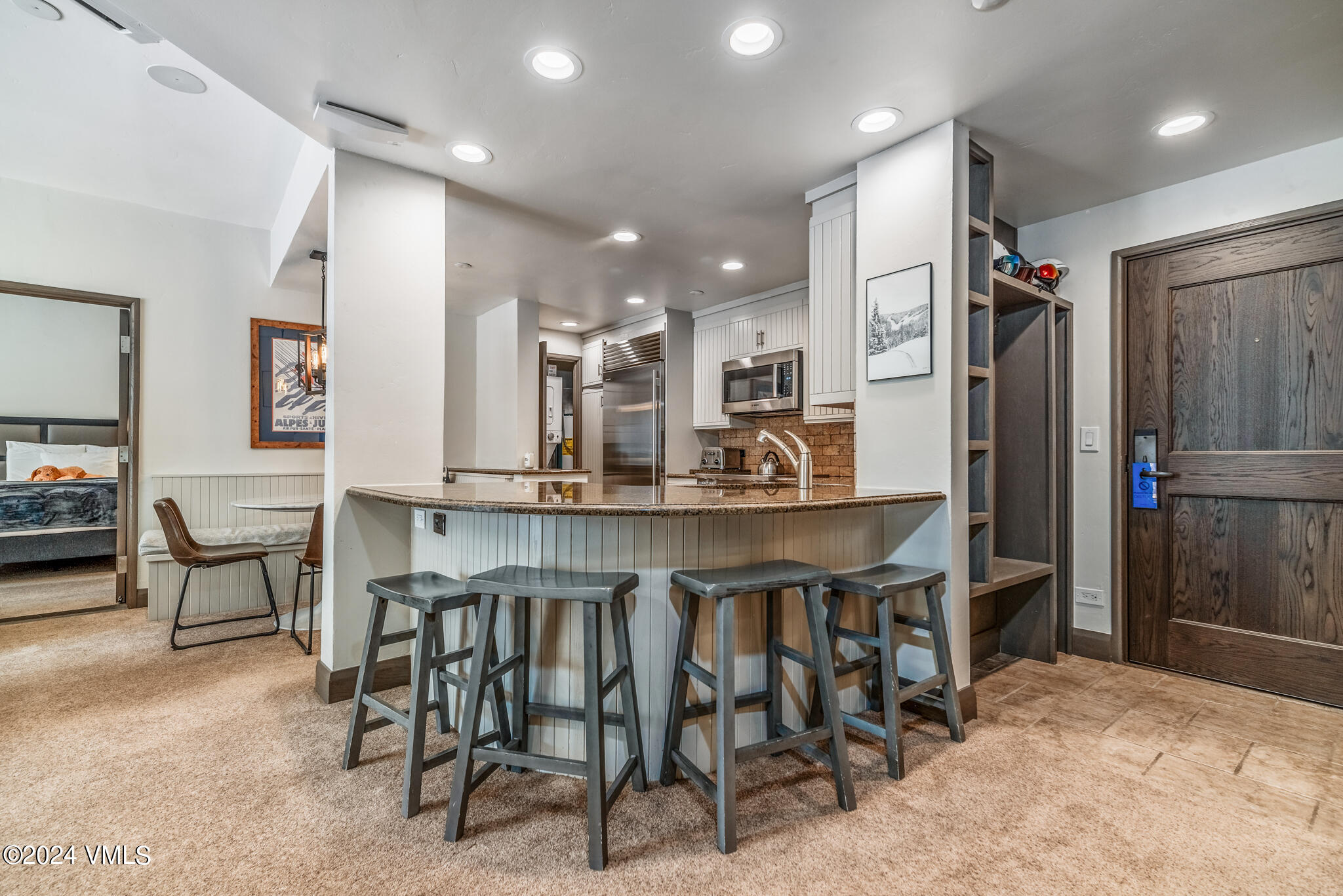 120 Offerson Road, Unit F230 Beaver Creek, CO 81620 - Photo 12 of 48 a kitchen with stainless steel appliances kitchen island granite countertop a table and chairs in it