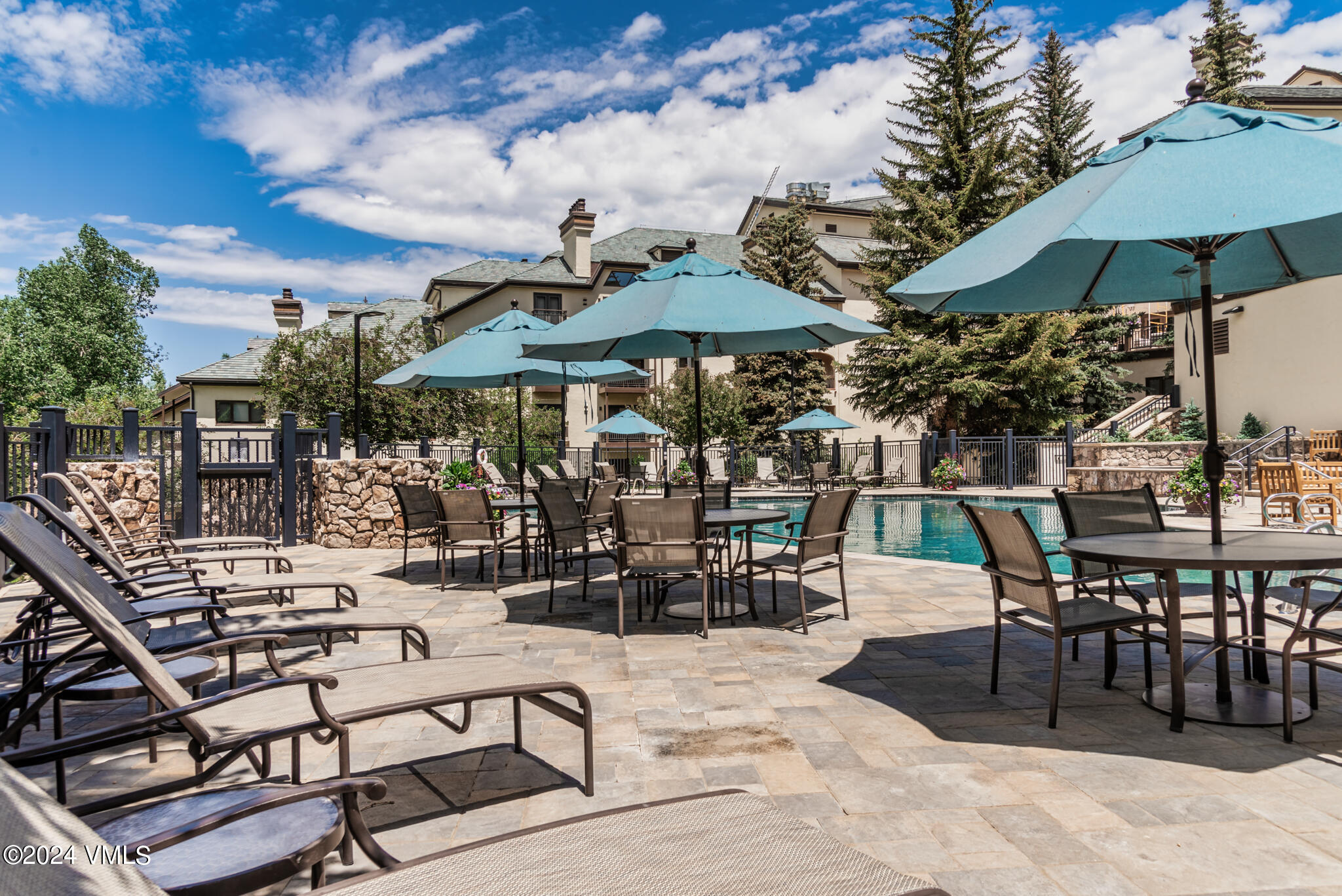 120 Offerson Road, Unit F230 Beaver Creek, CO 81620 - Photo 40 of 48 a view of a patio with dining table and chairs under an umbrella with a barbeque