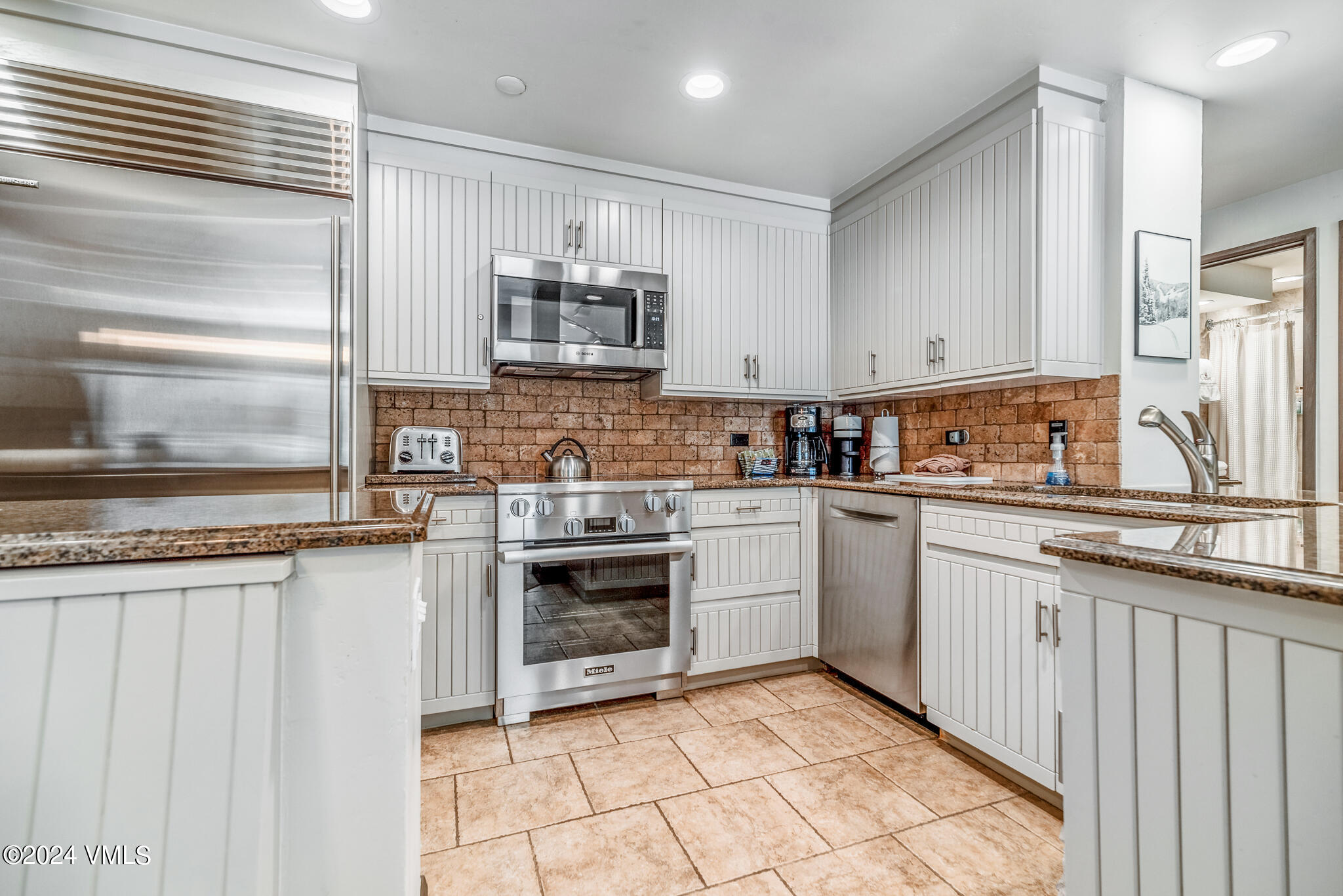 120 Offerson Road, Unit F230 Beaver Creek, CO 81620 - Photo 9 of 48 a kitchen with stainless steel appliances granite countertop a stove a sink and a refrigerator