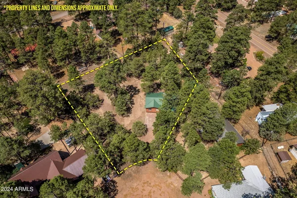 an aerial view of residential houses with outdoor space and trees