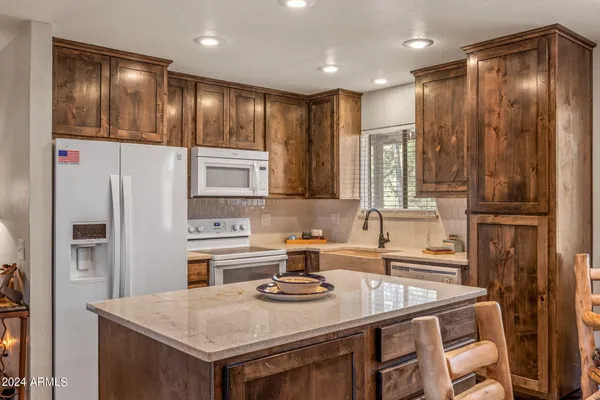 a kitchen with a sink a stove and chairs