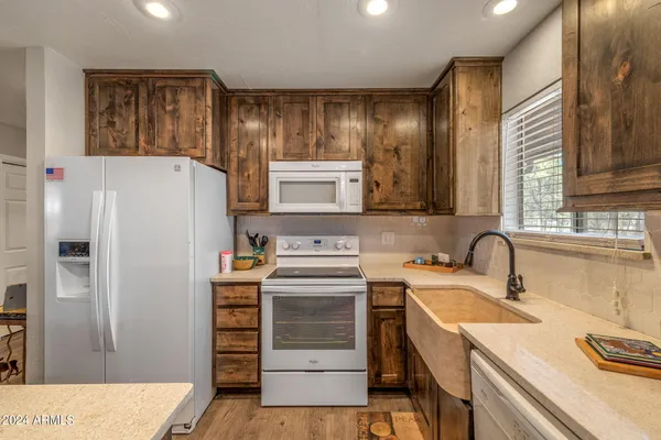 a kitchen with a refrigerator sink and cabinets