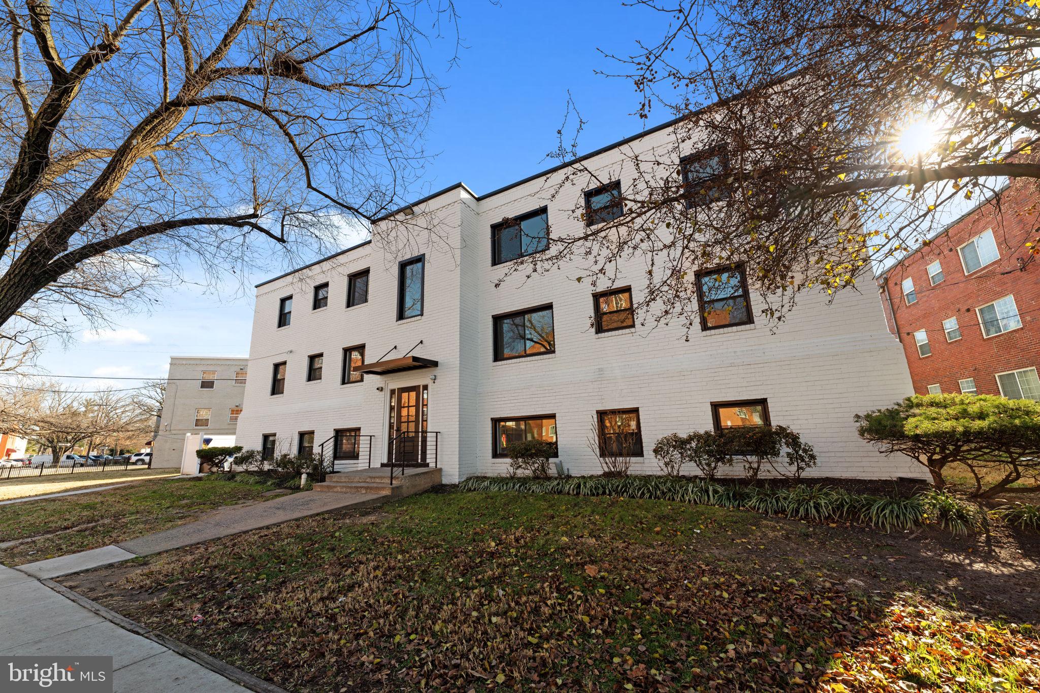 a view of a white house with a yard