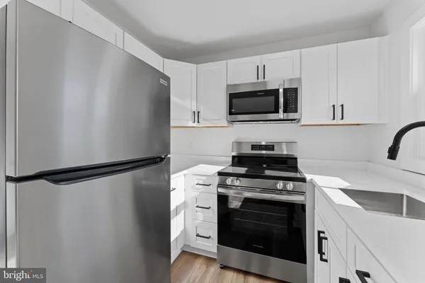 a kitchen with stainless steel appliances a refrigerator stove and microwave