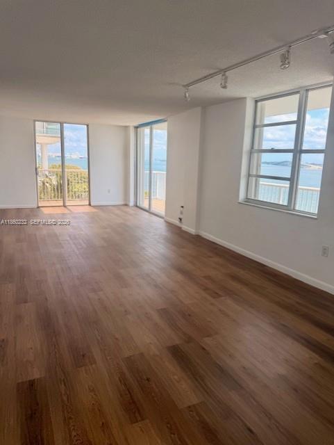 150 Southeast 25th Road, Unit 6A Miami, FL 33129 - Photo 8 of 20 a view of an empty room with a window and wooden floor