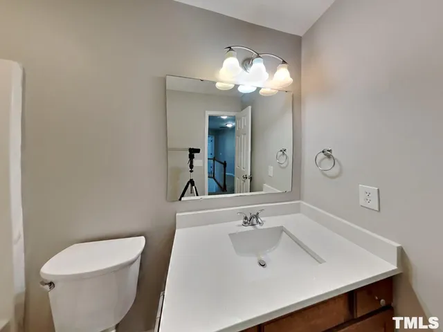 a bathroom with a sink a toilet and a mirror