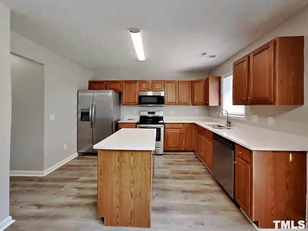 a kitchen with granite countertop a refrigerator stove top oven and sink