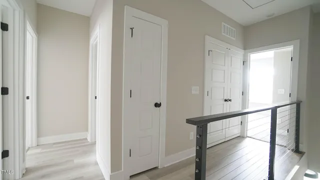 a view of a hallway with wooden floor and staircase