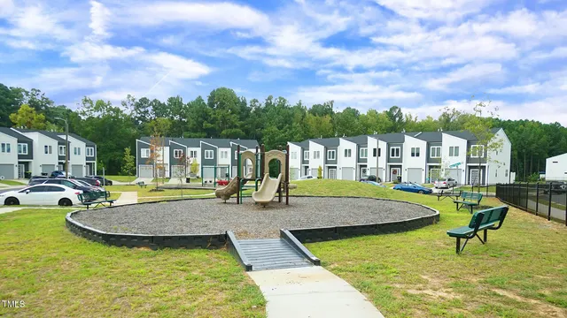 a view of swimming pool with outdoor seating and trees in the background