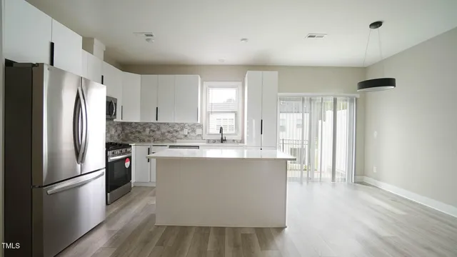 a kitchen with stainless steel appliances a refrigerator sink and cabinets