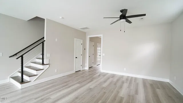a view of a room with wooden floor and stairs