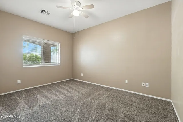an empty room with a window and a fan