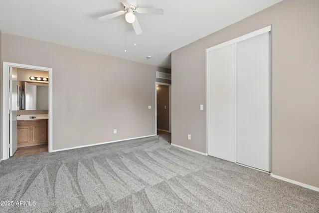 a view of an empty room with closet and a window