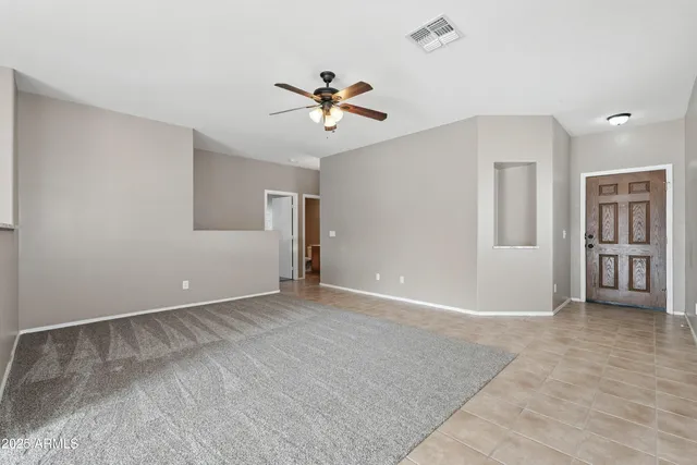 a view of an empty room with a ceiling fan