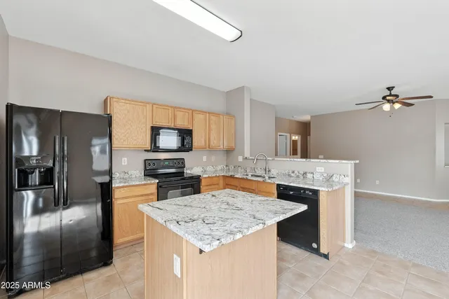 a kitchen with stainless steel appliances granite countertop a sink and a refrigerator