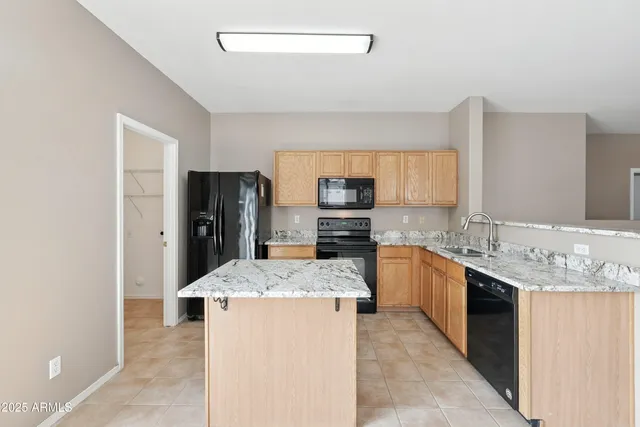 a kitchen with stainless steel appliances granite countertop a sink stove refrigerator and cabinets