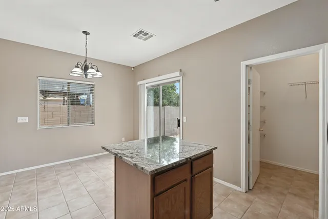 a kitchen with kitchen island granite countertop cabinets and window