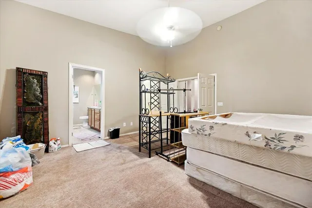 a spacious bedroom with a bed and a chandelier