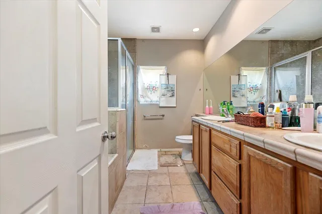 a spacious bathroom with a shower a sink and a mirror
