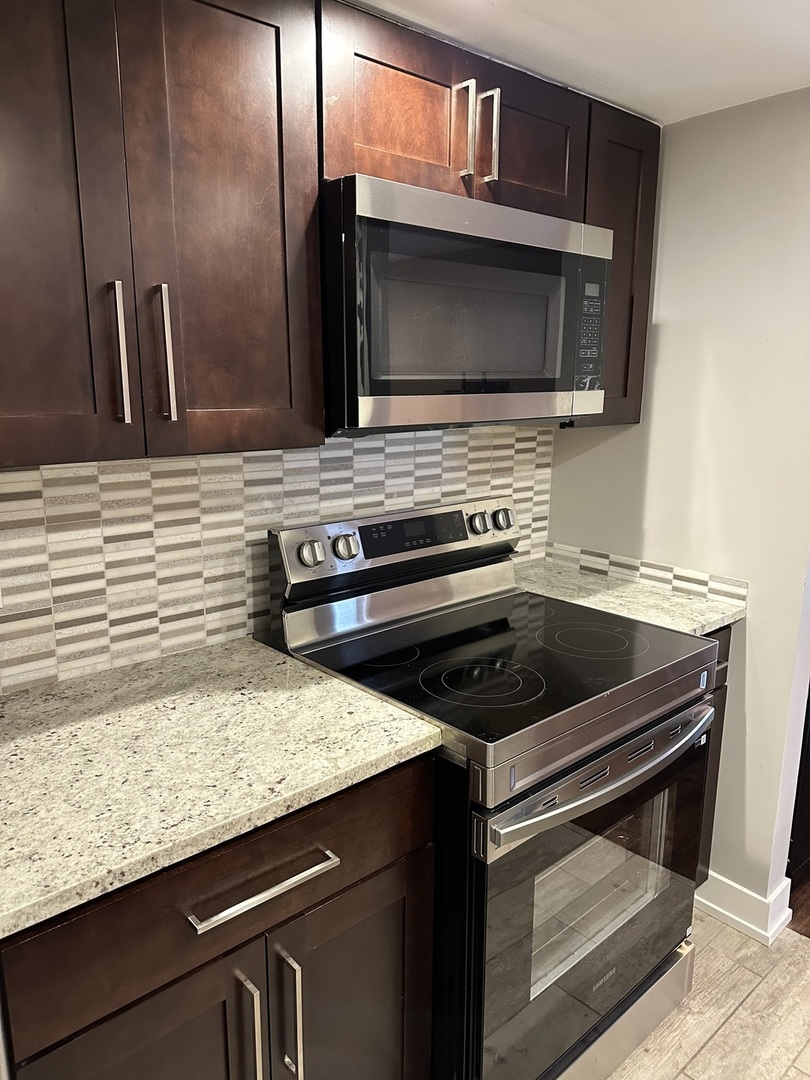 9830 Sayre Avenue, Unit 13 Chicago Ridge, IL 60415 - Photo 9 of 34 a kitchen with a stove and a microwave