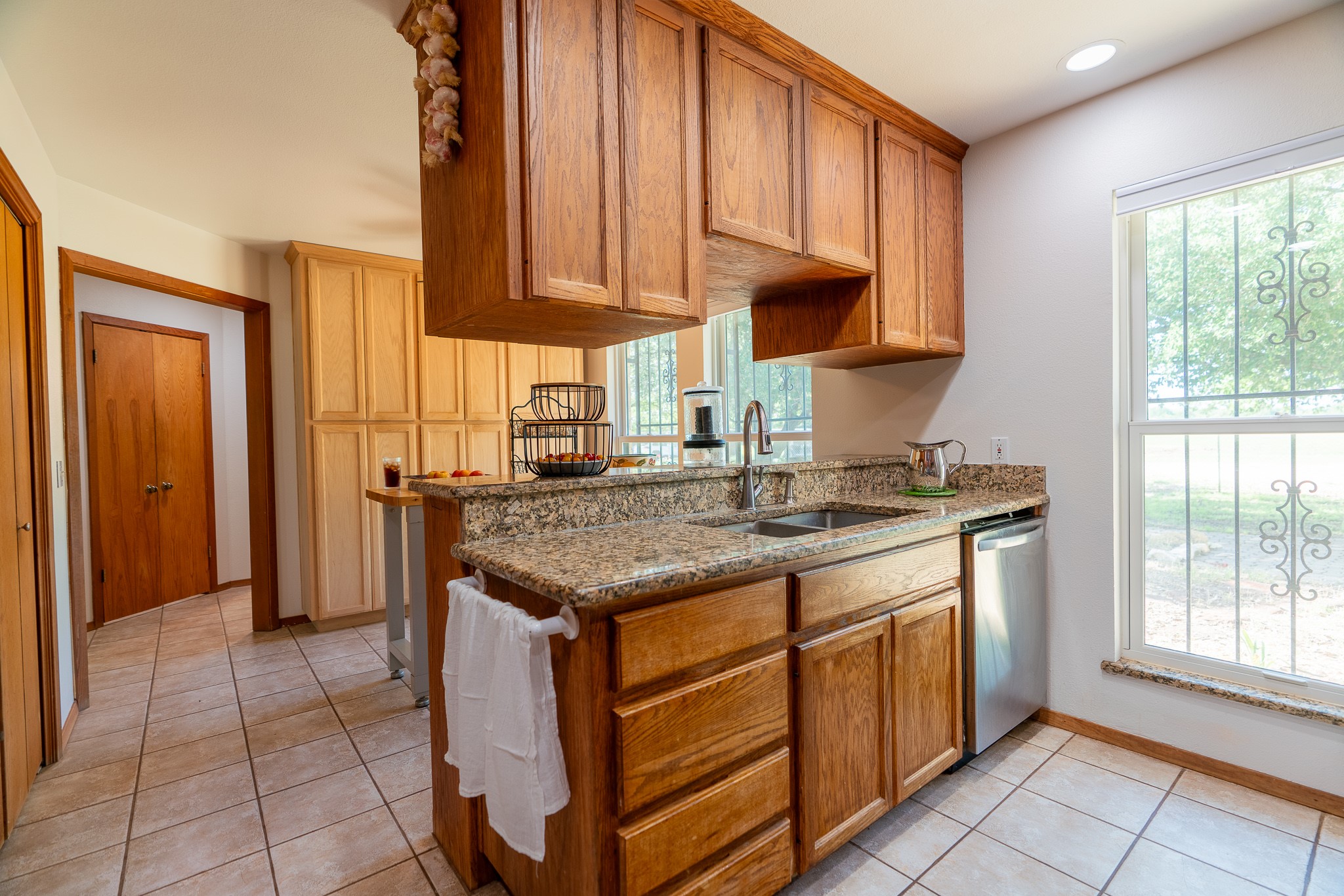400 619th Spur Elgin, TX 78621 - Photo 26 of 40 A well-lit kitchen features granite counters, ample cabinet space, and a stainless steel dishwasher.