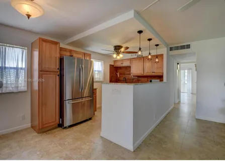 a kitchen with stainless steel appliances granite countertop a refrigerator and a stove