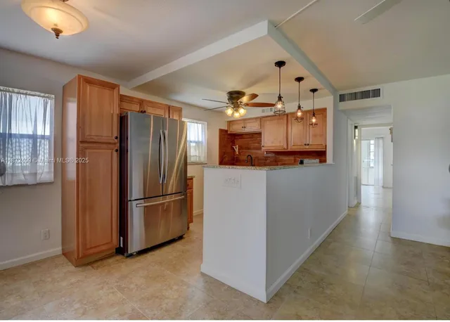 a kitchen with stainless steel appliances granite countertop a refrigerator and a stove