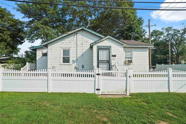 a view of a house with a yard and fence