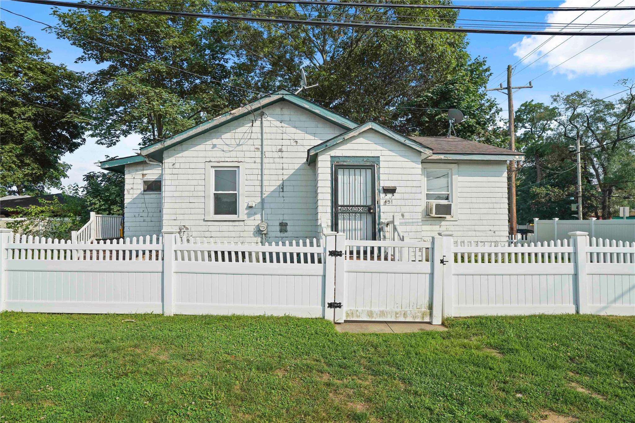 a view of a house with a yard and fence