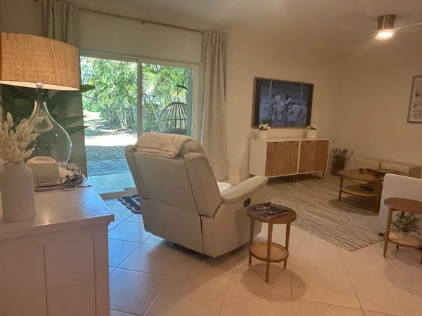 a living room with furniture a large window and a wooden floor