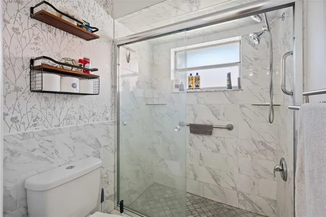 a bathroom with a shower a toilet and a sink