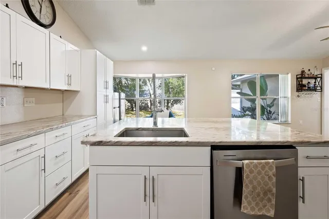 a kitchen with granite countertop white cabinets and white appliances