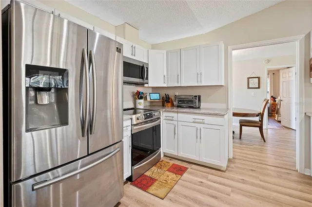 a kitchen with granite countertop a refrigerator stove and sink