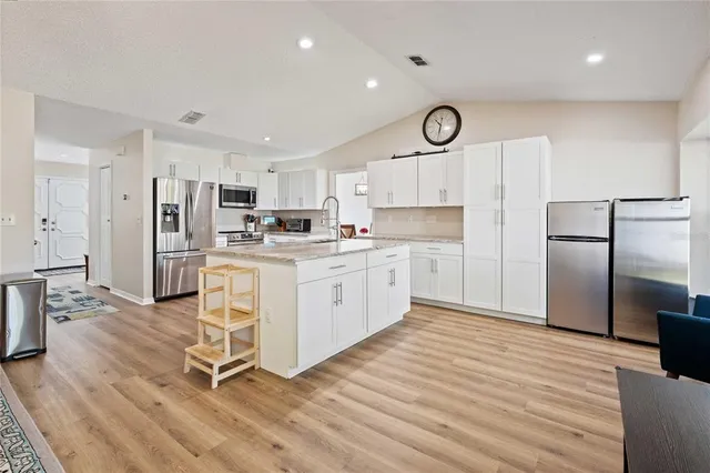 a kitchen with a refrigerator a oven cabinets and a sink