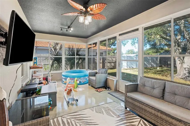 a living room with furniture a flat screen tv and a floor to ceiling window