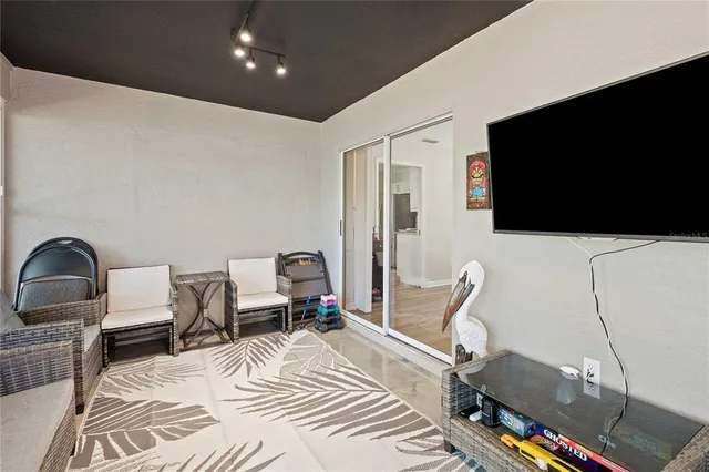 a bedroom with a bed a couch and a flat screen tv