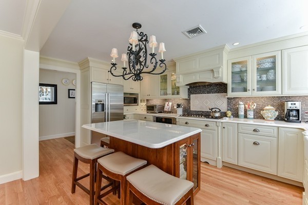 11 Alden Road Wellesley, MA 02481 - Photo 12 of 29 a kitchen with stainless steel appliances a table chairs and a refrigerator
