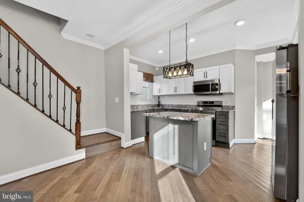 a kitchen with stainless steel appliances a stove top oven a sink and a refrigerator
