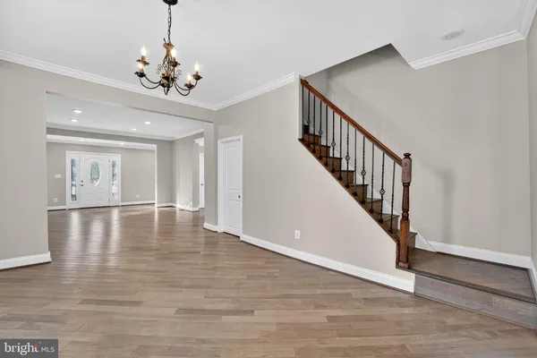 a view of an room with wooden floor chandelier and entryway