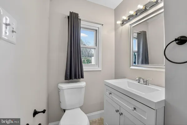 a bathroom with a toilet a sink and mirror