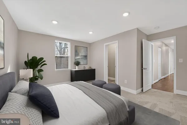 a bedroom with a large bed and a potted plant